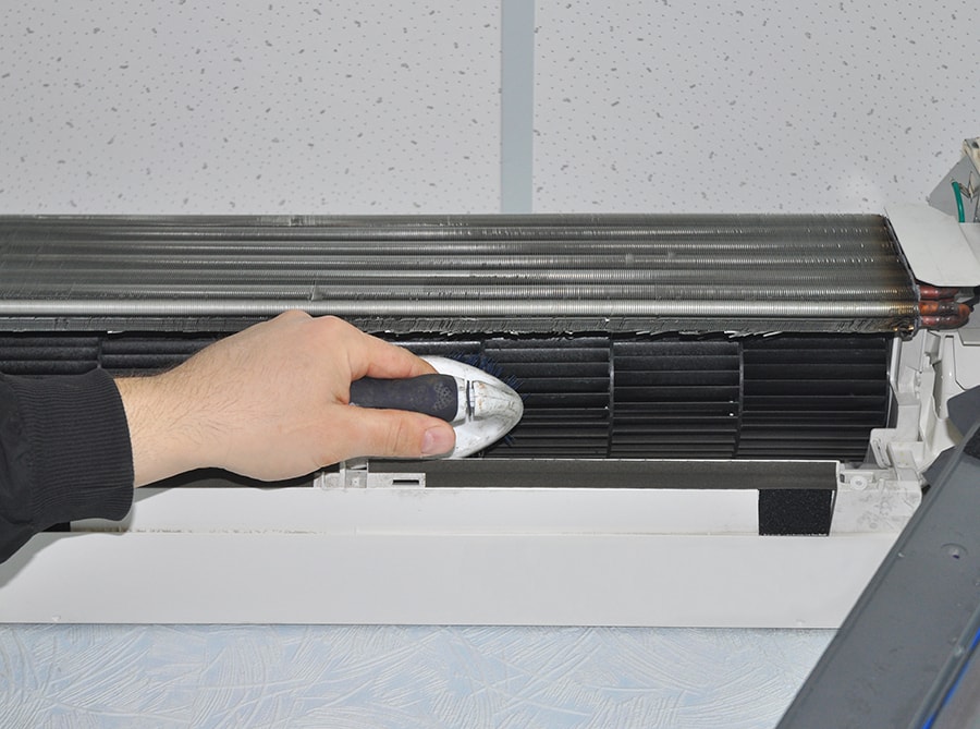 Close up on Air Conditioner Cleaning with Brush.