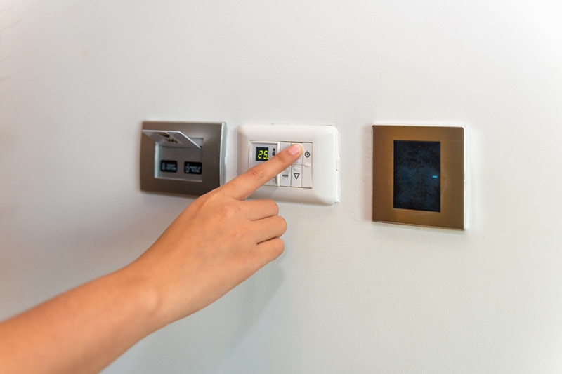 person controlling their heat pump with their thermostat