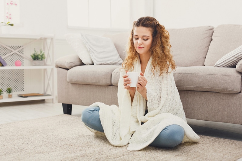 Cozy girl indoors with a cup of tea, 5 Reasons to Schedule a Fall Furnace Clean & Check | Heating Services