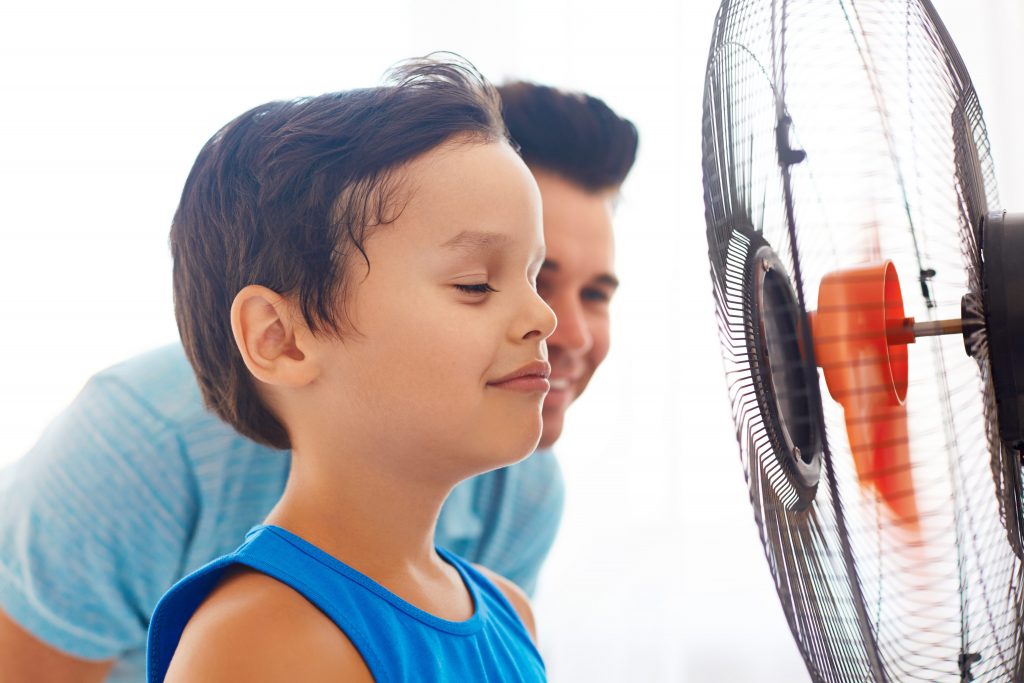 Boy in front of a fan because he needs a new heat pump in Hudson